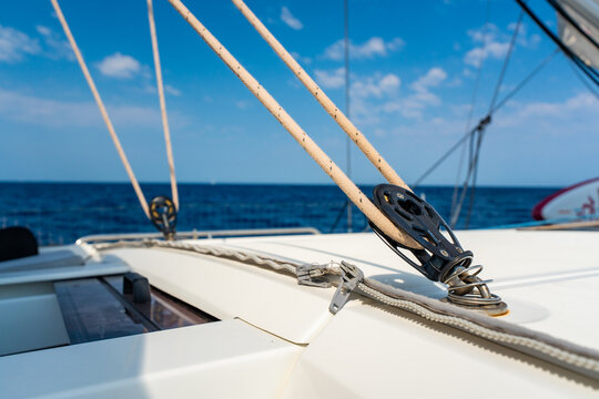 Sailboat deck hardware with rope and pulley under sail. Yacht rigging and sailing equipment during navigation at sea.