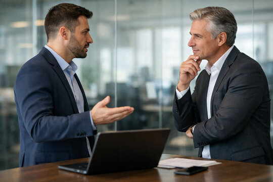 Cybersecurity consultant explains security risk assessment to company executive, discussing cyber threats, data protection, risk management and business security strategy in modern office copy space