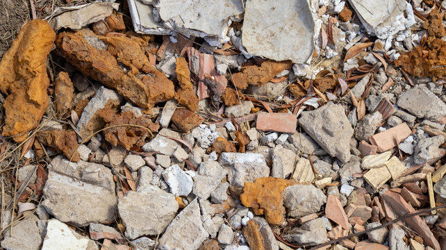 Detalle visual de fragmentos constructivos triturados sobre terreno seco