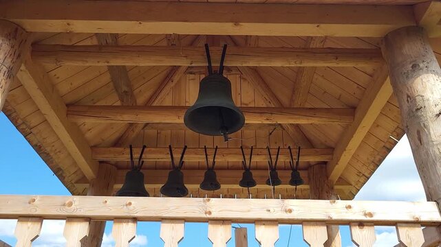 Small freestanding wooden belfry with hanging bells