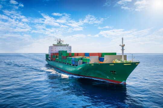 Aerial front view of a container cargo ship traveling over calm ocean