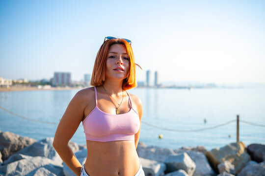 Redhead woman posing at coastal promenade enjoying summer