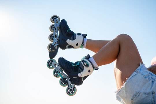 Woman wearing inline skates against blue sky