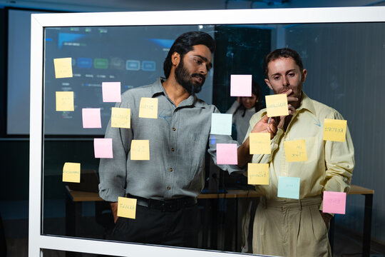 Software Engineers Team Collaborating on Project Planning with Sticky Notes, Reviewing Development Challenges, Prioritizing Technical Tasks and Discussing Software Implementation Strategy.