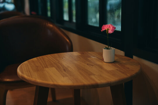 minimal wooden table with pink carnation pot