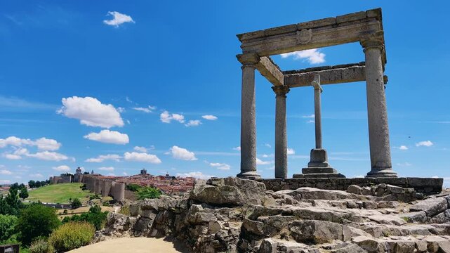 Ancient stone monument overlooking the historic walled city of Avila in Spain under blue sky