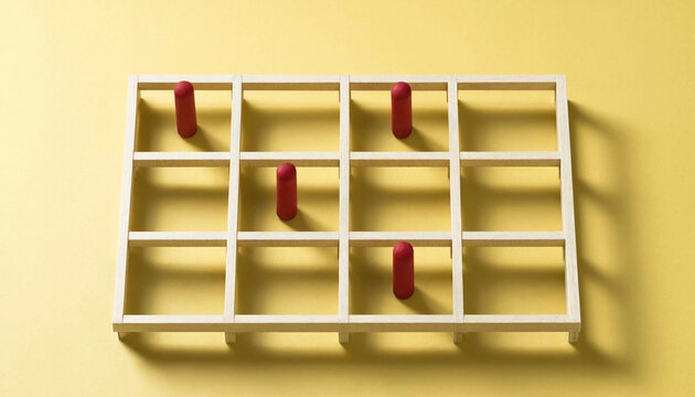 Strategy concept with red pegs on wooden grid against yellow background symbolizing planning and decision making