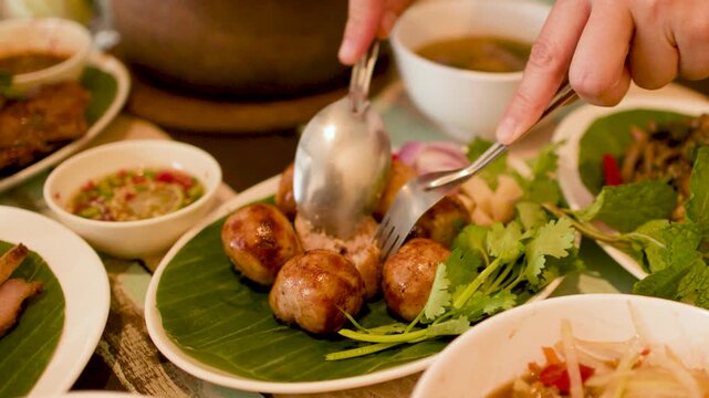 Cutting Thai Isan Fermented Sausages with Spoon and Fork