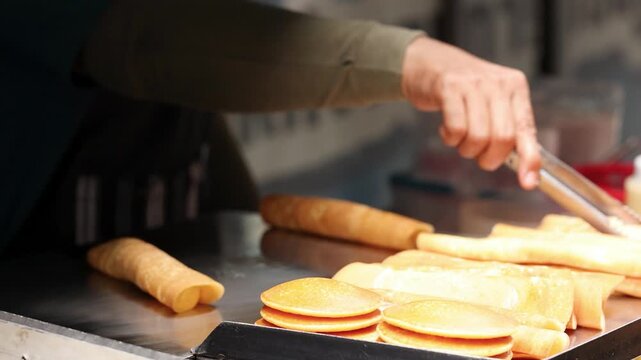 Street Vendor Cooking Thai Crepes on Hot Griddle in Bangkok