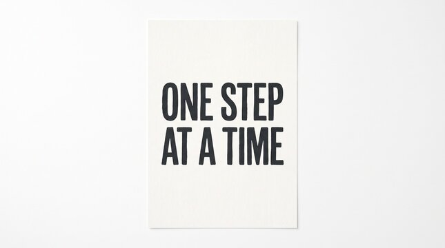 Motivational Quote One Step At A Time Written on White Paper.