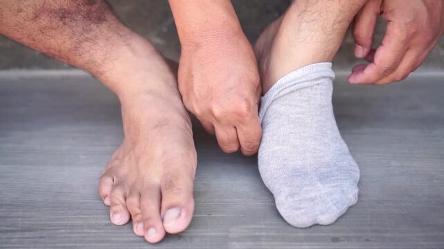 Man release on grey socks, morning routine preparation, dressing and getting ready concept.