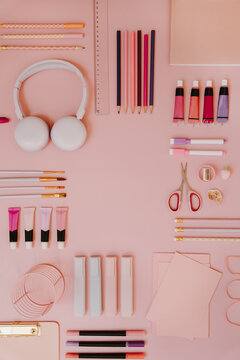 Top View Pink Desk Accessories Layout With Headphones, Stationery, And Blank Center For Text