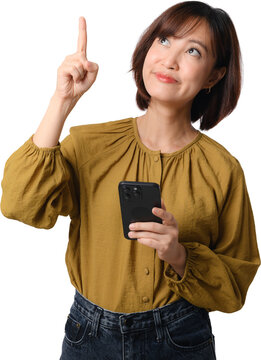 Happy asian woman holding smartphone pointing finger up with curious expression looking aside isolated on transparent background