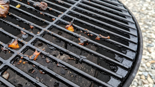 Dirty cast iron barbecue grill grate covered with burnt food residue needing cleaning