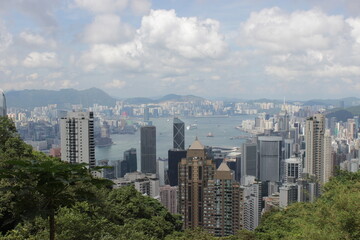 Fototapeta premium Panoramic view of Hong Kong skyline with Victoria Harbour and lush green hills