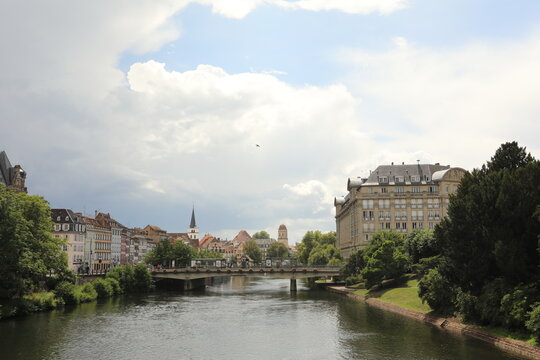 Strasbourg cityscape with river and historic buildings under cloudy sky
