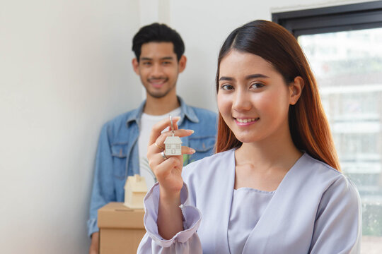 Young couple holding a house key after buy new home