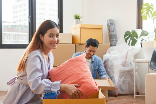 two people packing stuff into cardboard relocation to new apartment