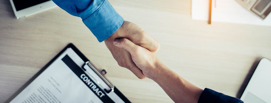 Banker and client hand shaking in office