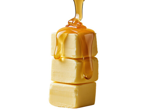 Golden honey pouring over a stack of fresh butter cubes on a white background