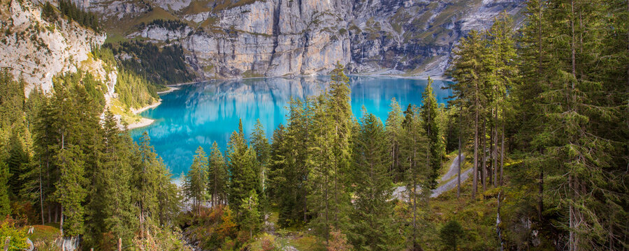 Oeschinensee Kandersteg Swiss Alps Switzerland turquoise mountain lake surrounded by pine forest and steep rocky cliffs