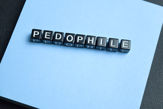 Pedophile text stacked wooden cubes on the table. For child protection awareness