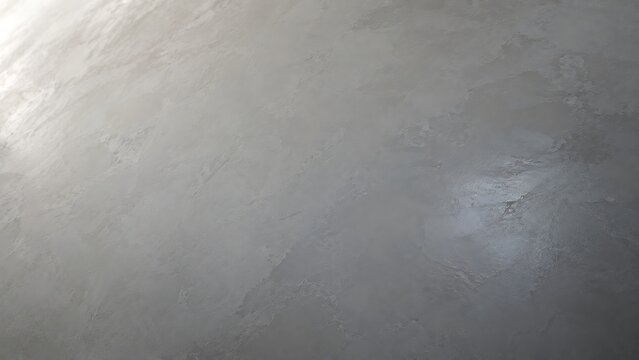 Close-up view of a textured grey surface with subtle reflections and uneven patterns, resembling polished concrete or metal.