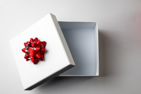 Open White Gift Box with Red Ribbon Bow on White Background