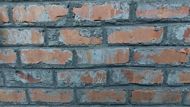 Full frame texture of old red brick wall with grey cement mortar smear.