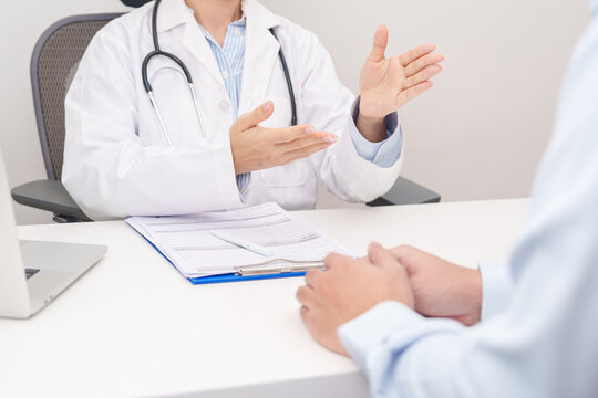 Doctor and patient having a medical consultation in a hospital room, explaining a treatment plan, discussing diagnosis, and giving advice during a medical health checkup appointment in a clinic