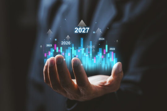 Business professional holds virtual financial chart with 2027 growth projection, representing investment, market analysis, business forecast, economic progress, and future success.