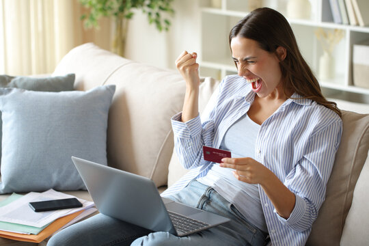 Excited teleworker paying online using computer and card