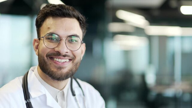 Portrait of smiling doctor in white coat in hospital clinic looking at camera. Happy medical worker physician in glasses in office. Empty copy space for writing text. Template for advertising Close up