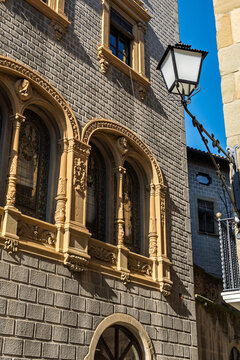 Ornate stone building facade with stained glass in Vic, Spain.