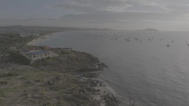 Aerial drone view of Mui Ne fishing village and Ganh Da Mui Ne coastline in Lam Dong, Vietnam, with fishing boats at sea, sandy beaches and a scenic coastal landscape.