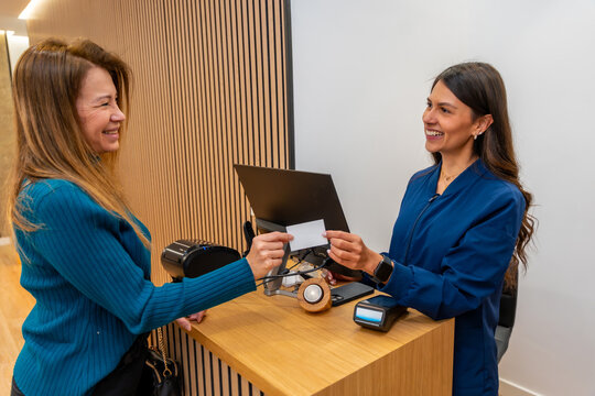Woman paying for beauty services with credit card at clinic reception