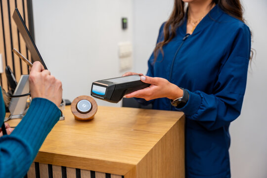 Patient making contactless payment at aesthetic clinic reception