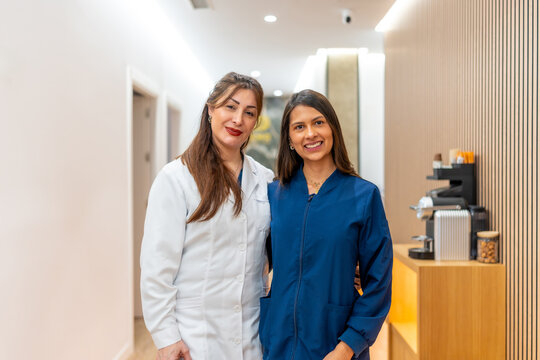 Female doctors in aesthetic clinic hallway smiling