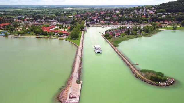 Moving away and slowly ascending, the drone reveals Fony&oacute;d harbor and the shoreline of Lake Balaton in Hungary.