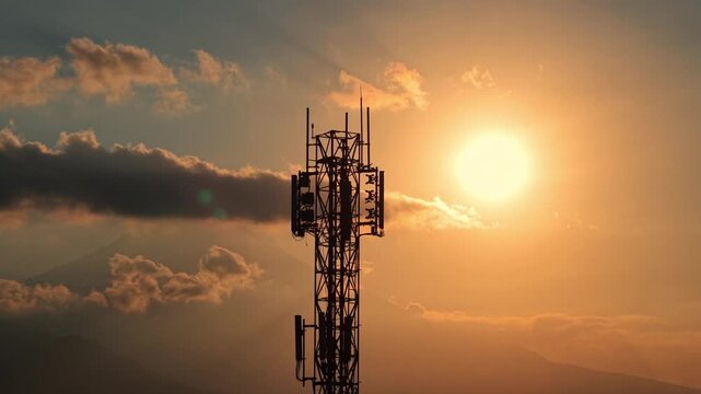 Telecom tower standing tall against orange sunset sky, silhouette view. Network infrastructure, connectivity, and technology concept footage.