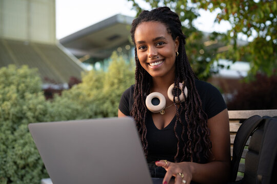 A African American woman works on her laptop outdoors