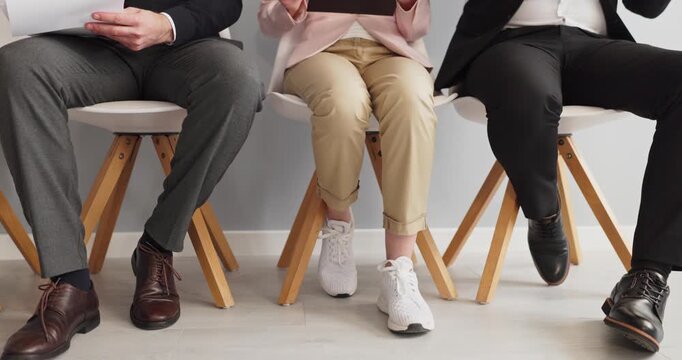 Candidates waiting interview, applicants seated for recruitment. Three people sit in a row on chairs, legs visible, in mixed business attire, anticipating hiring . Strong concept of hiring selection.