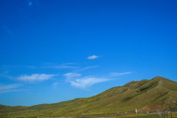 Fototapeta premium Clear Blue Sky Over Green Rolling Mountain Landscape