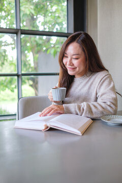Vertical portrait image of a woman reading a book and drinking coffee