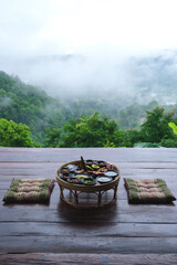 Fototapeta premium A set of breakfast on Northern Thai traditional dining table with foggy mountain views