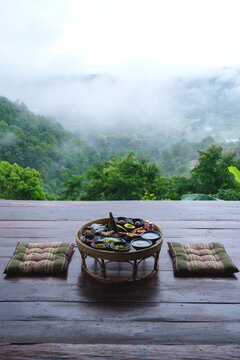 A set of breakfast on Northern Thai traditional dining table with foggy mountain views