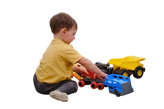 Toddler boy sitting on floor playing with toy construction truck. Happy child learning through imaginative builder activity. Preschool development and fun creative childhood concept.