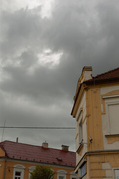 Historic corner building under storm clouds, ornate facade and rooftop details against dramatic sky, moody atmosphere with looming weather and heritage