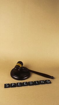 Wooden gavel and sound block next to the word speeding, symbolizing the legal consequences and punishment for traffic violations and exceeding the speed limit, representing law and order
