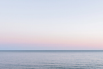 Fototapeta premium Serene Ocean Horizon Line Under Pastel Sunrise Sky